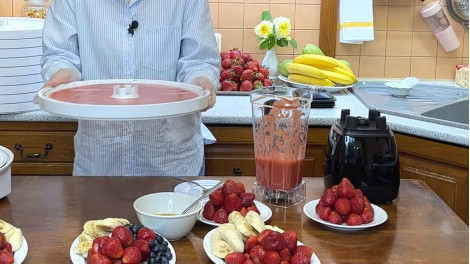 Суцільний піддон Ezidri на лотку, повністю залитий ягідним пюре, у руках перед закладанням у сушарку