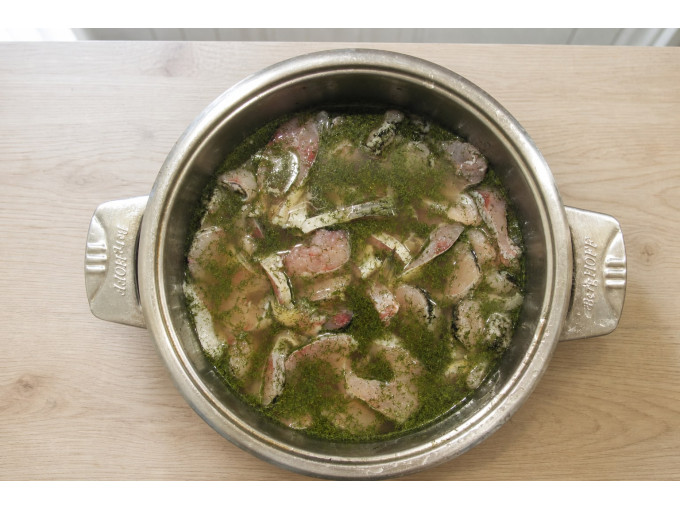 Рассол с укропом и чесноком в кастрюле, залитая рыба